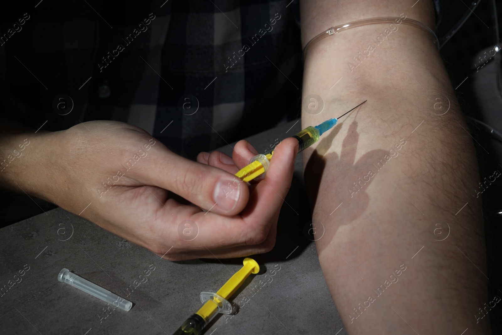 Photo of Addicted man taking drugs at grey table, closeup