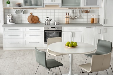 Photo of Stylish kitchen interior with dining table and chairs