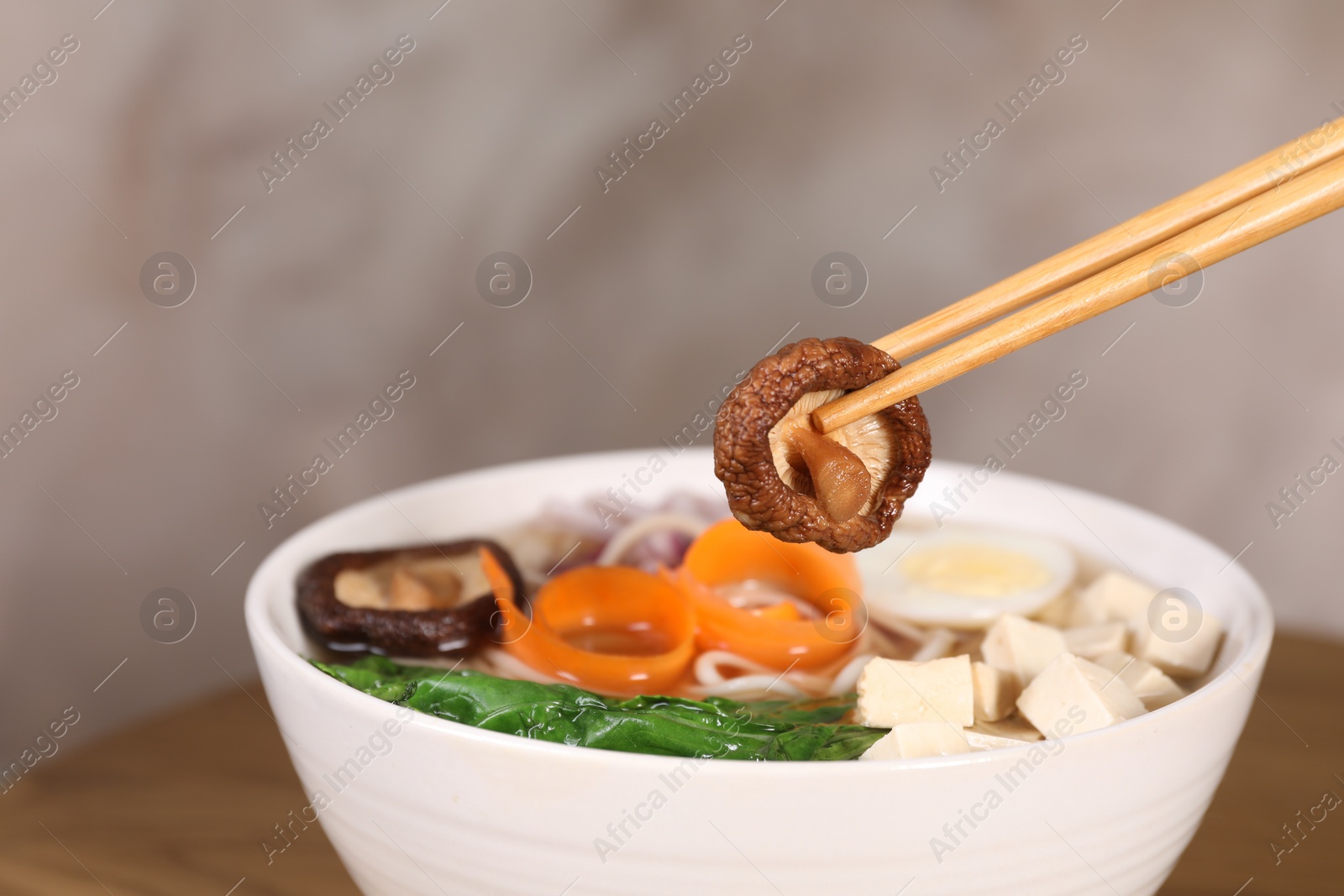 Photo of Eating delicious vegetarian ramen at table, space for text. Noodle soup