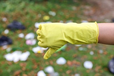 Photo of Woman showing thumb down in park, closeup. Garbage collection