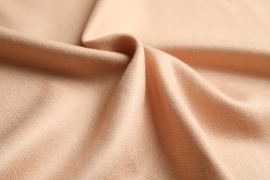 Beige soft cashmere fabric as background, closeup