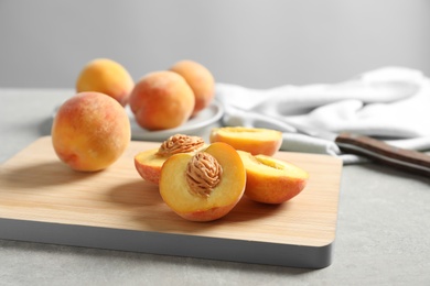 Wooden board with fresh sweet peaches on table, closeup