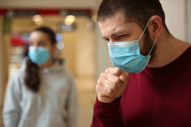 Photo of Man wearing disposable mask indoors. Dangerous virus