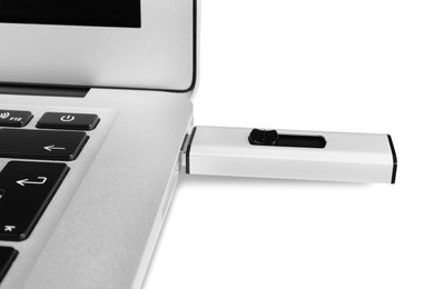 Photo of Modern usb flash drive attached into laptop on white background, closeup