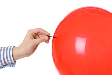 Photo of Woman piercing red balloon on white background, closeup