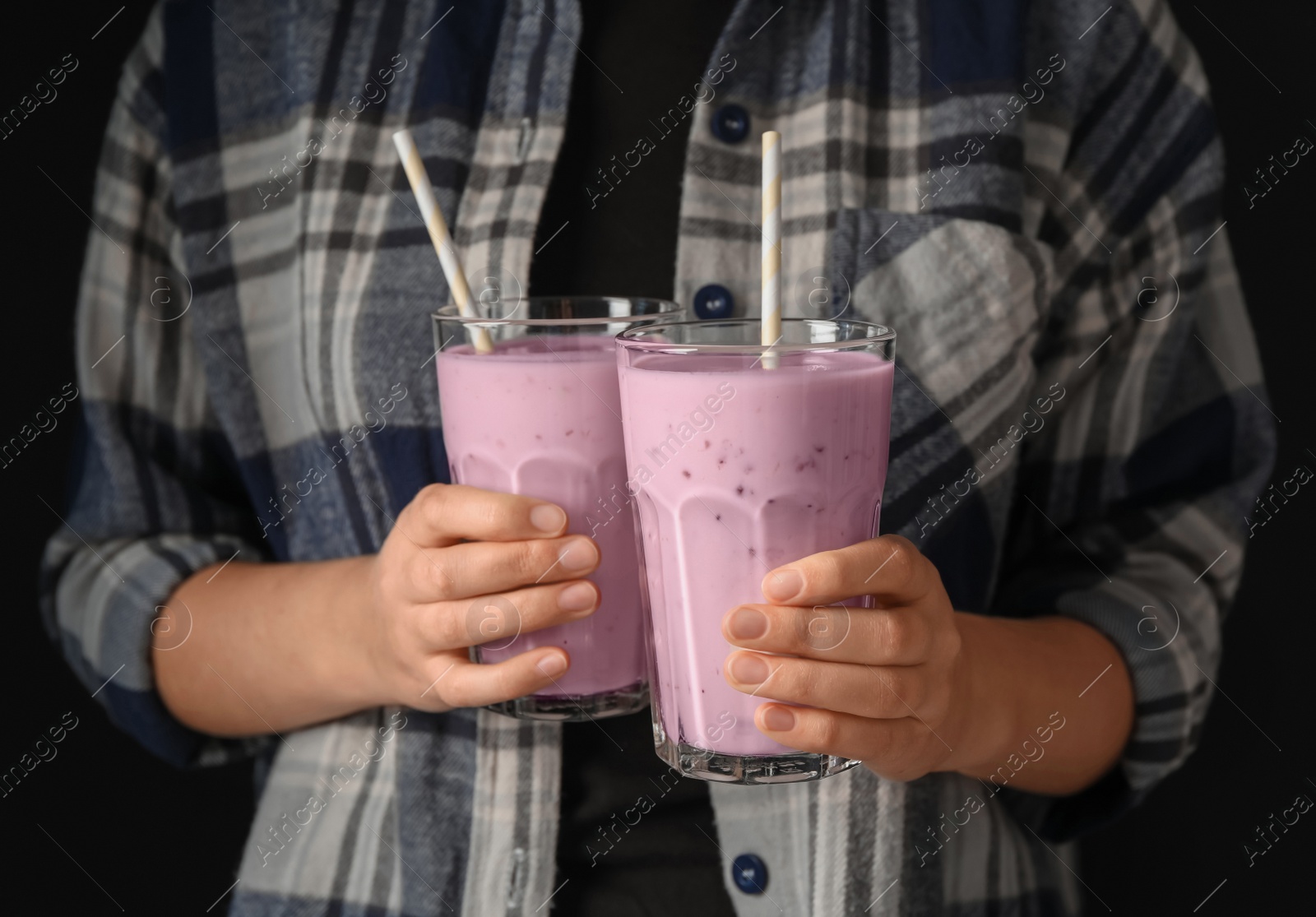 Photo of Woman holding fig smoothie on black background, closeup