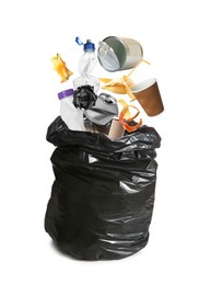 Different garbage falling into trash bag on white background