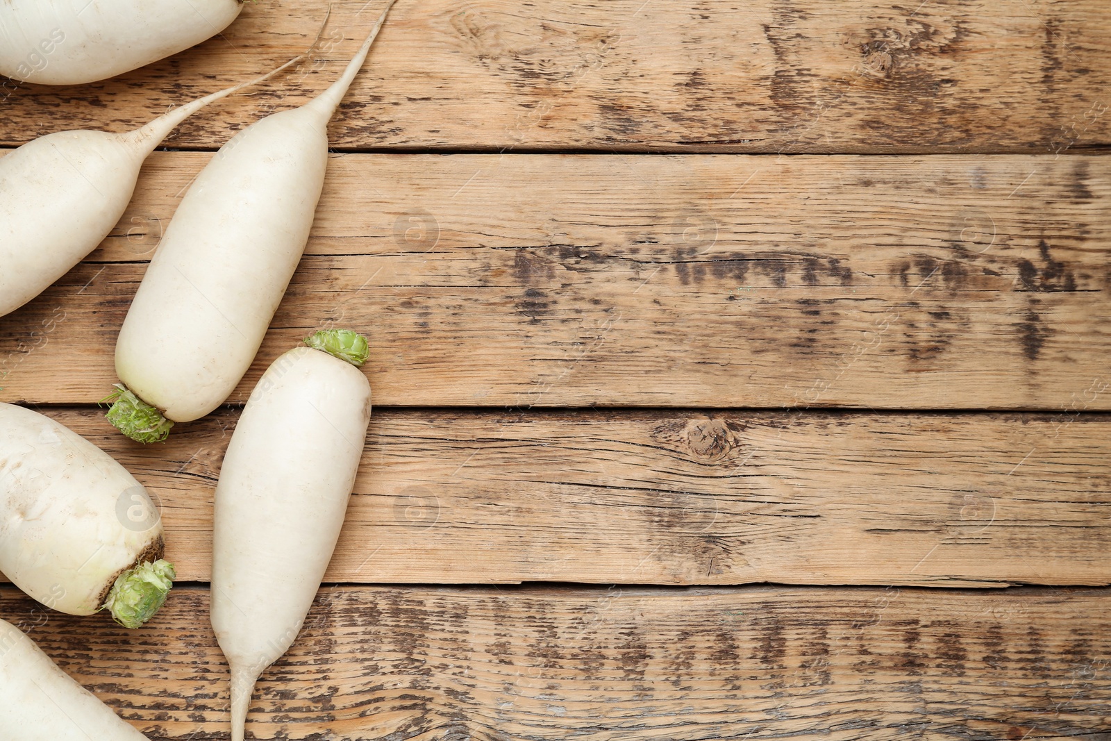 Photo of White turnips on wooden table, flat lay. Space for text