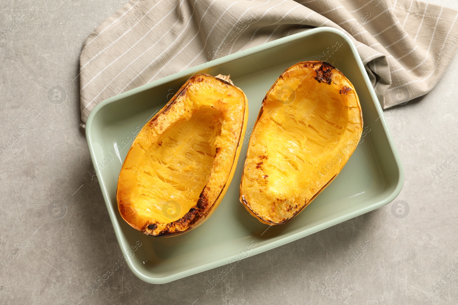Photo of Cooked spaghetti squash in baking dish on table, top view