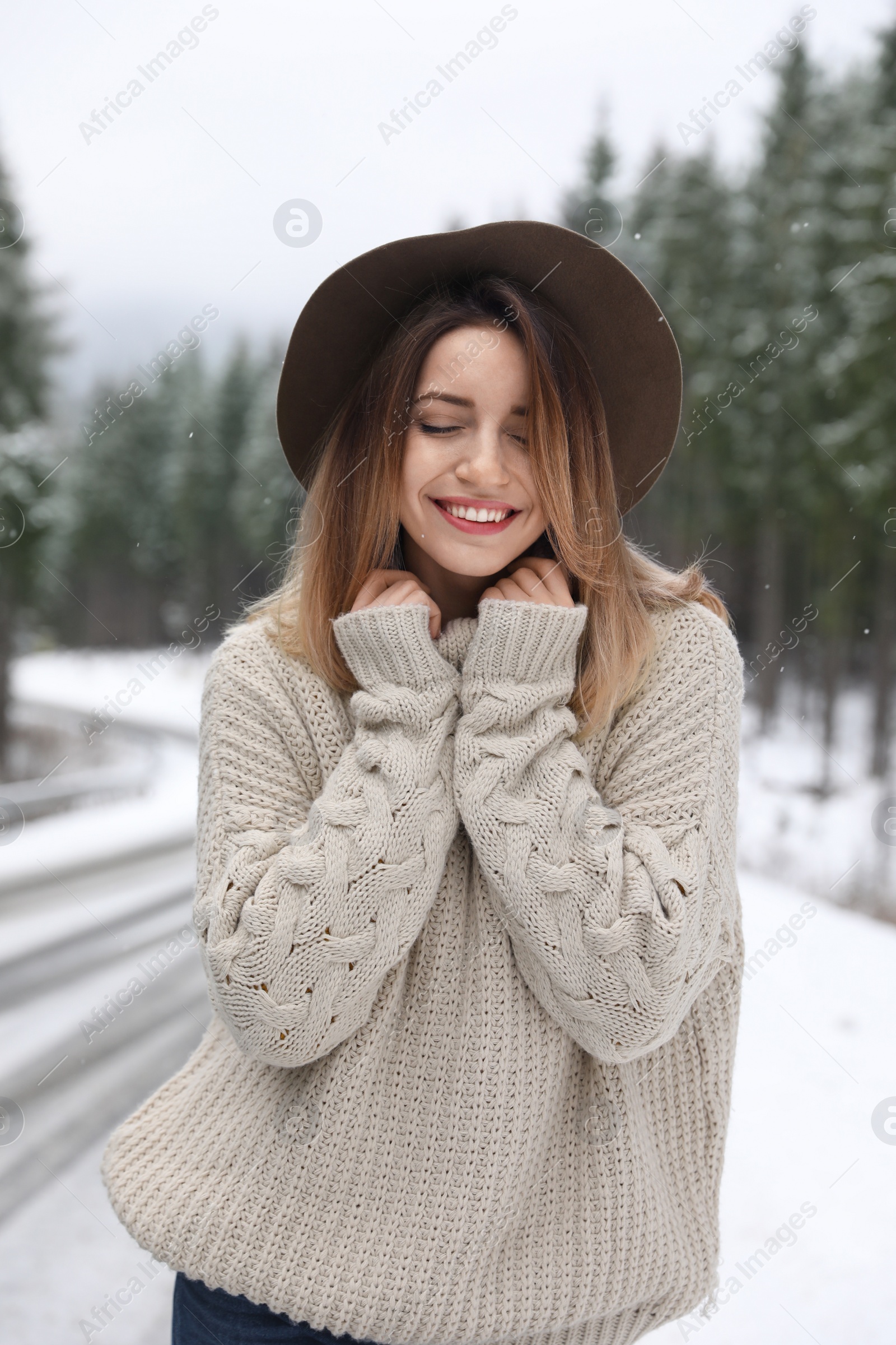 Photo of Young woman in warm sweater outdoors on snowy day. Winter vacation