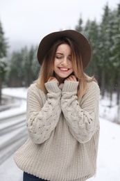 Photo of Young woman in warm sweater outdoors on snowy day. Winter vacation