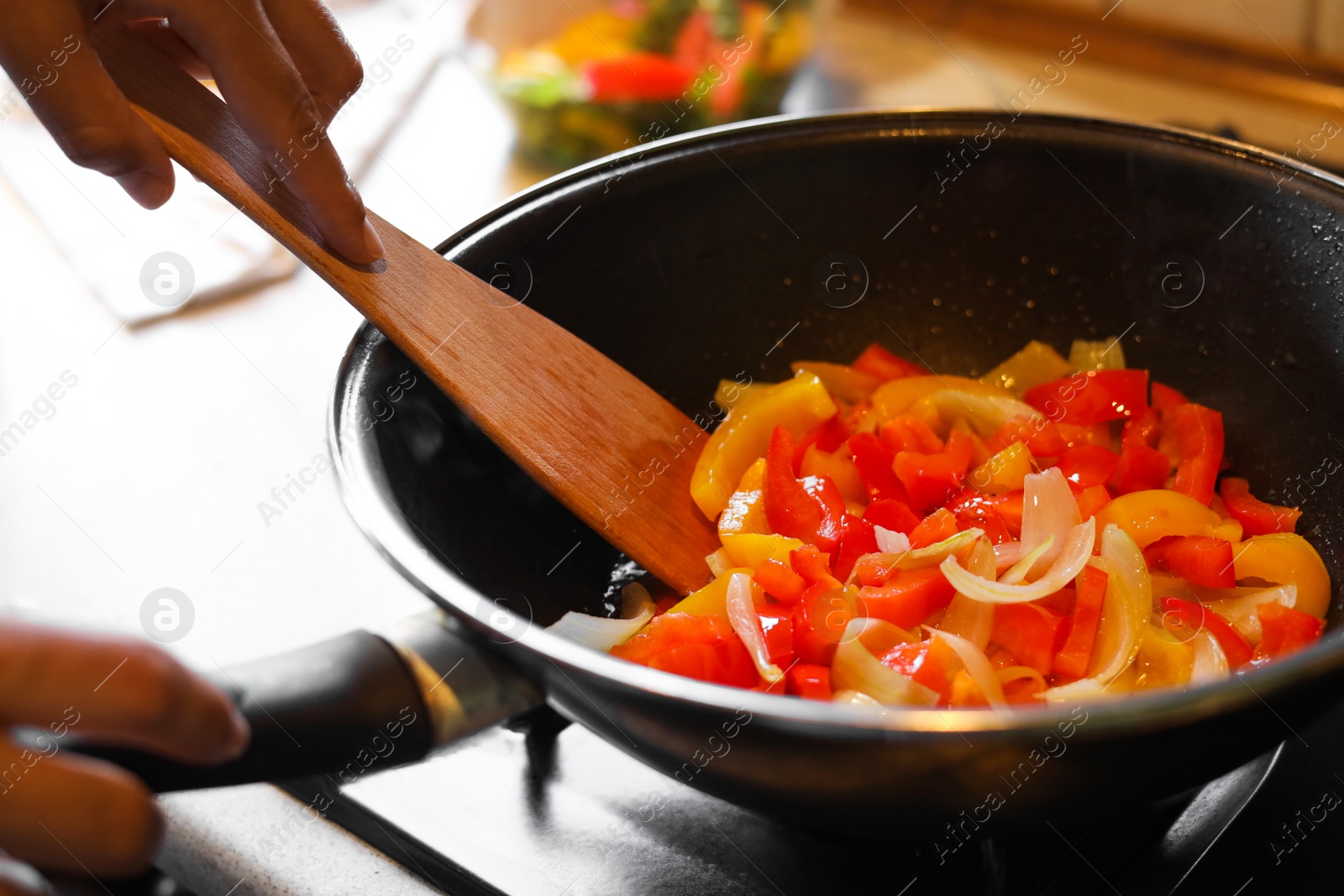 Photo of Woman cooking vegetables in frying pan indoors, closeup