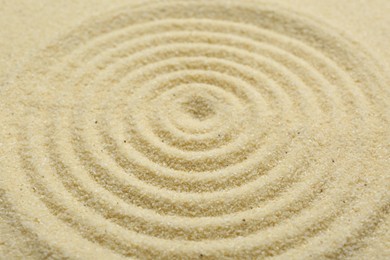 Photo of Zen rock garden. Circle pattern on beige sand, closeup