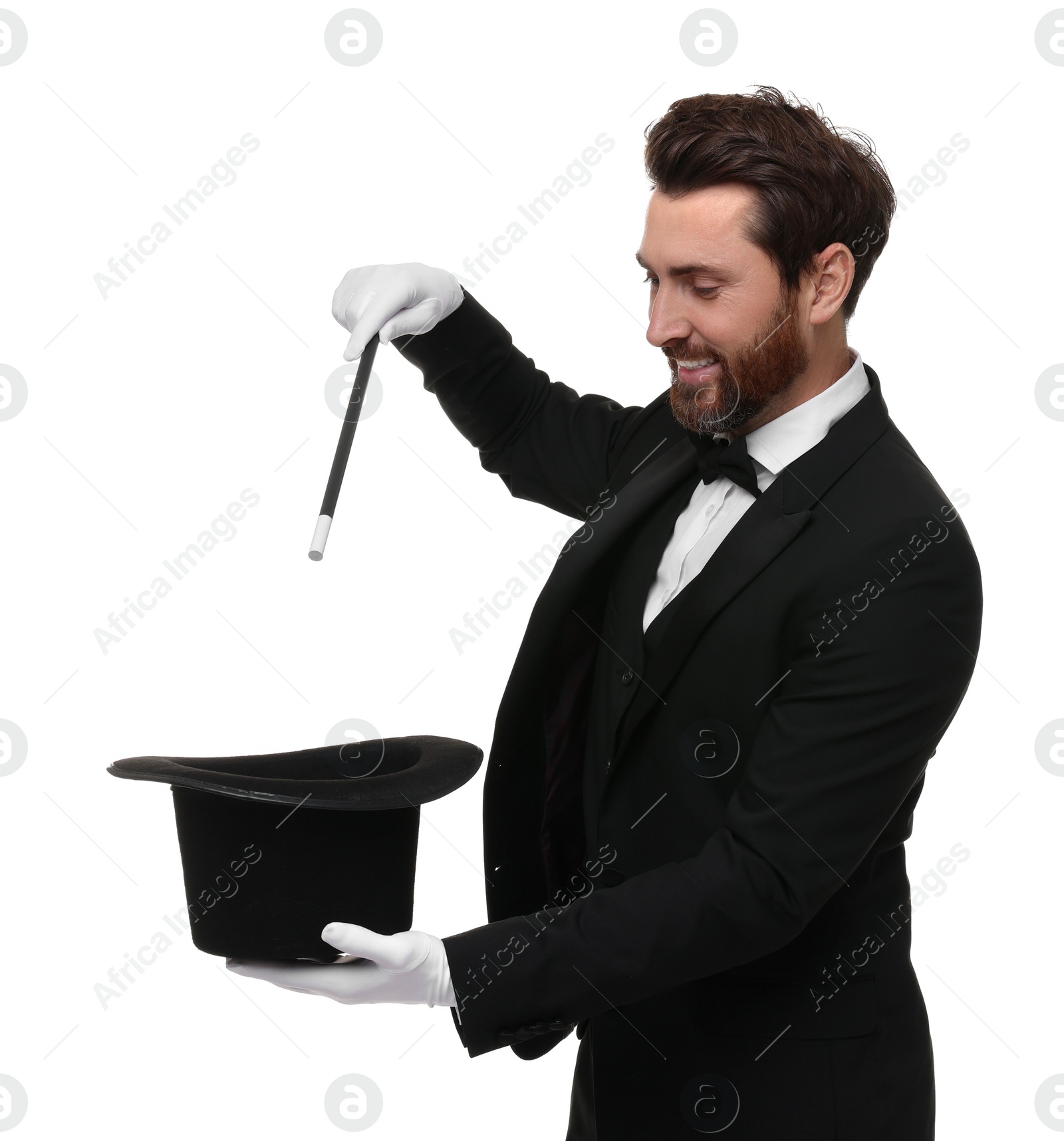 Photo of Happy magician showing magic trick with top hat on white background