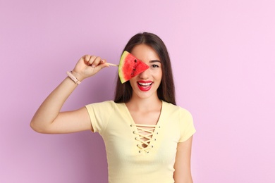 Photo of Beautiful young woman posing with watermelon on color background