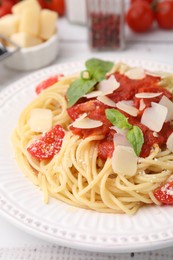 Tasty pasta with tomato sauce, cheese and basil on white table, closeup