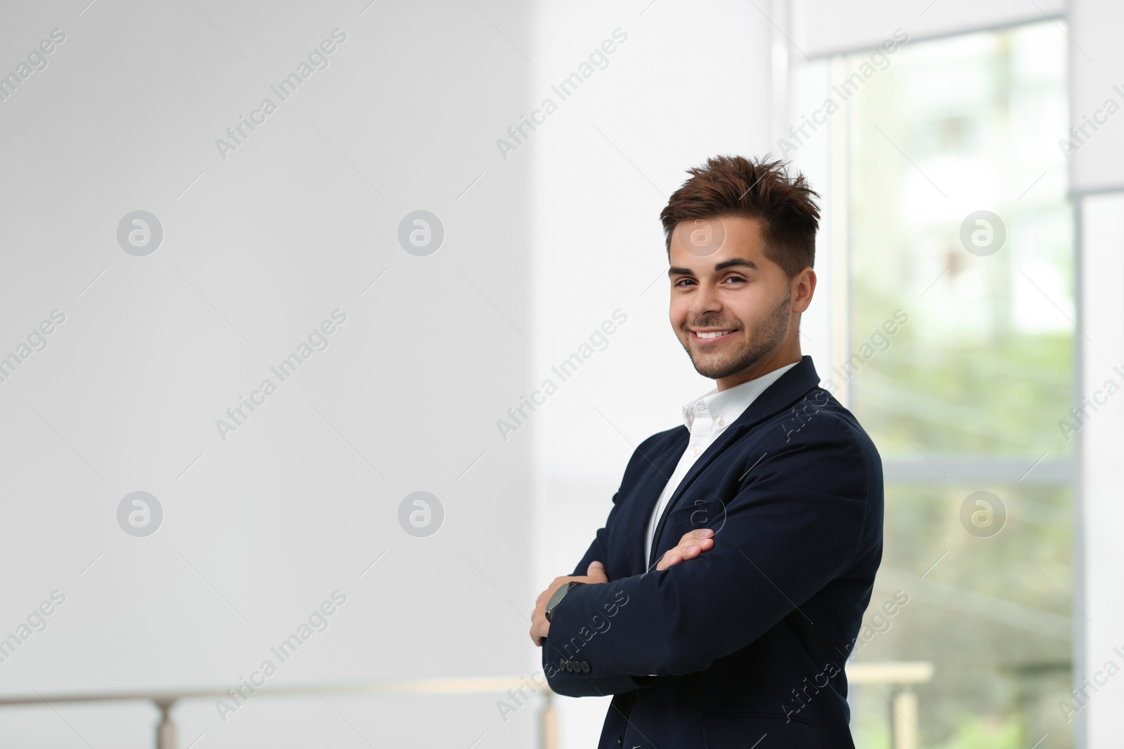 Photo of Portrait of handsome young man in elegant suit indoors. Space for text