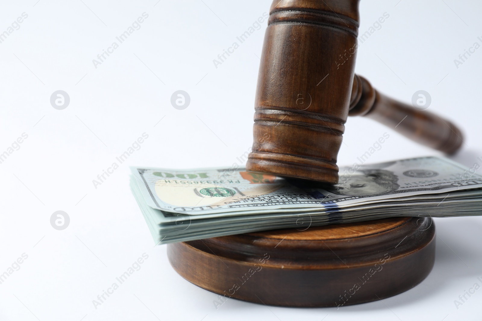 Photo of Law gavel with stack of dollars on white background, closeup. Space for text