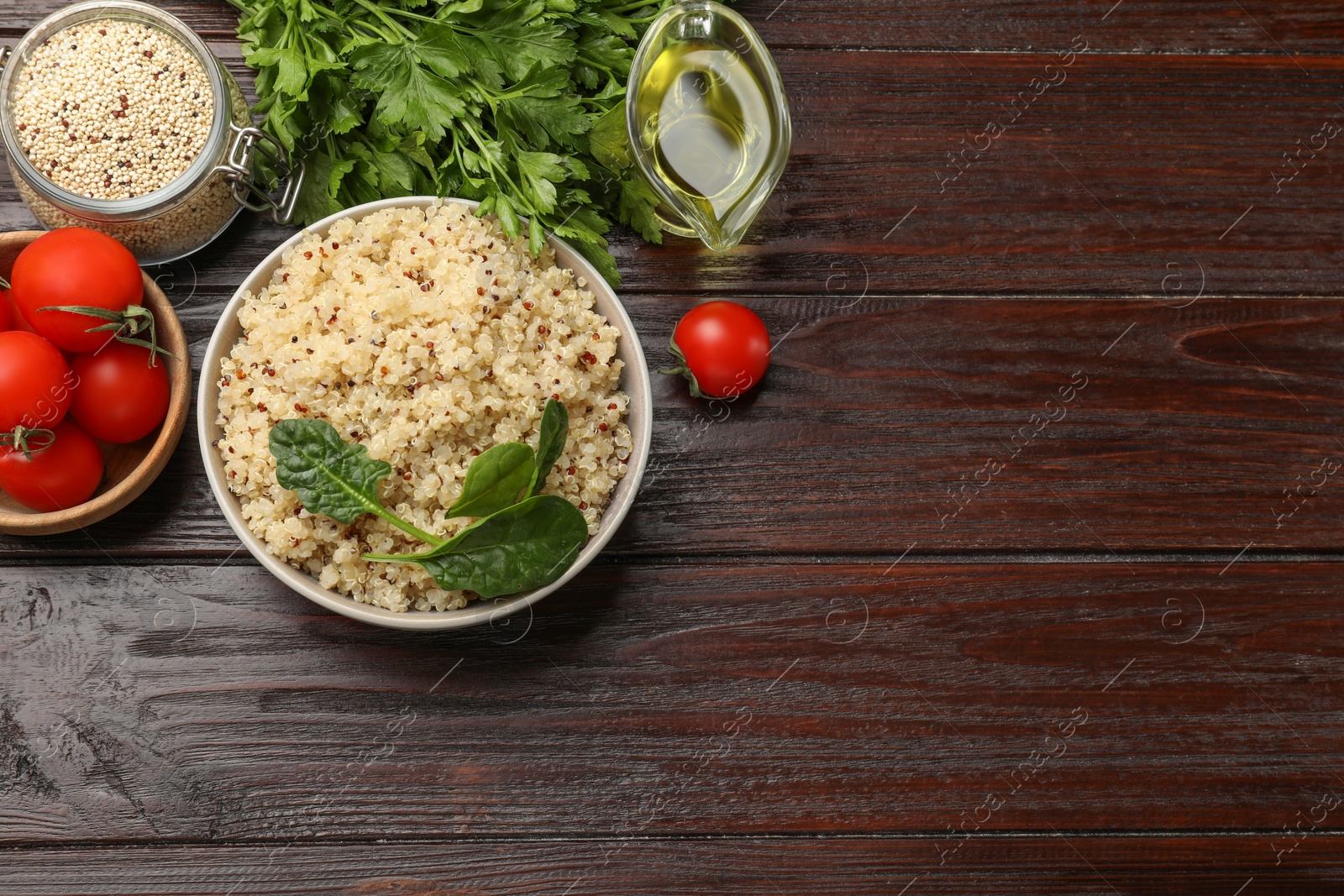 Photo of Tasty quinoa porridge in bowl, vegetables and seeds on wooden table, flat lay. Space for text