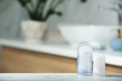 Different deodorants on table in bathroom, space for text