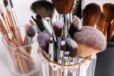 Photo of Set of professional makeup brushes on white background, closeup
