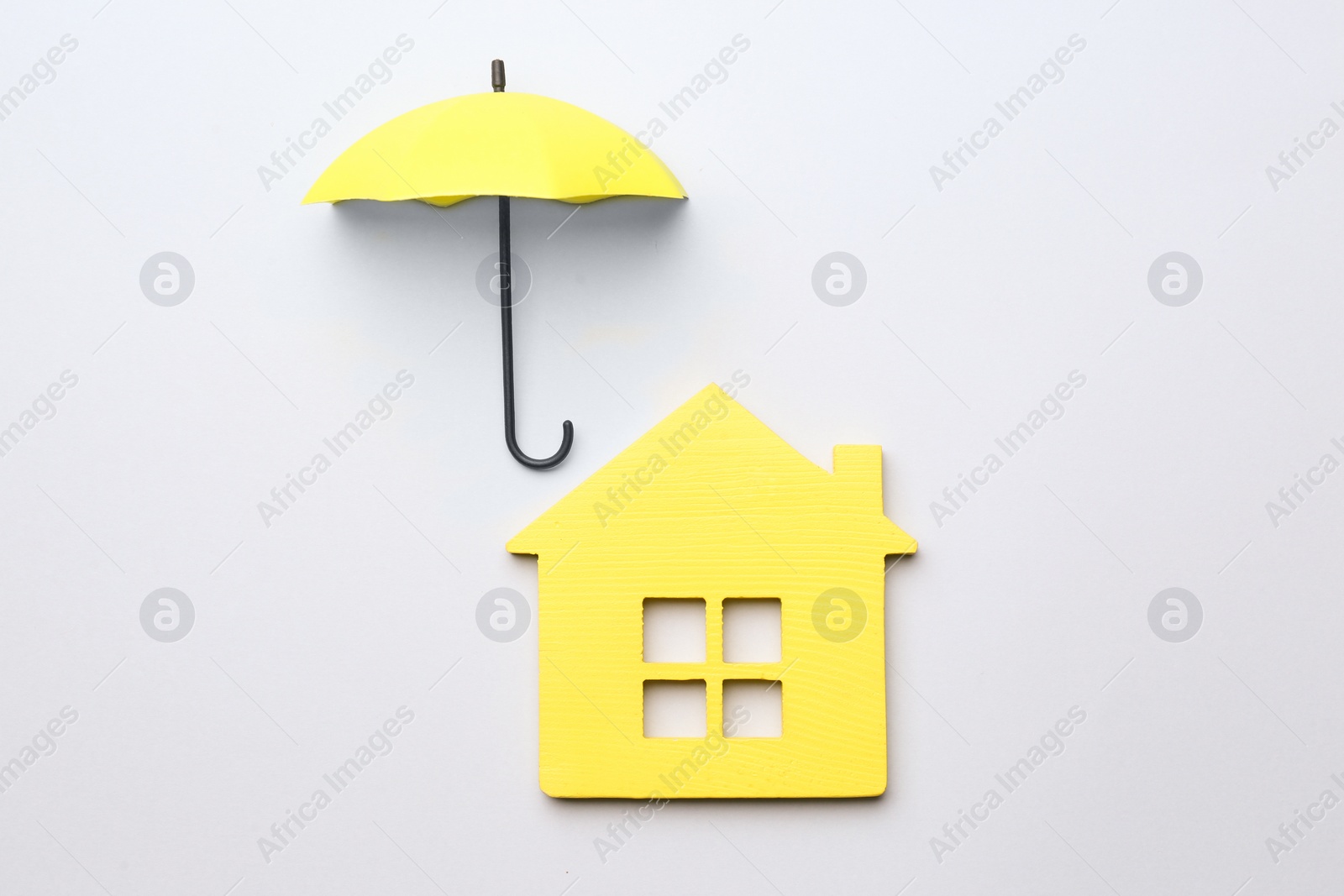 Photo of Mini umbrella and house model on white background, top view
