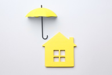 Photo of Mini umbrella and house model on white background, top view