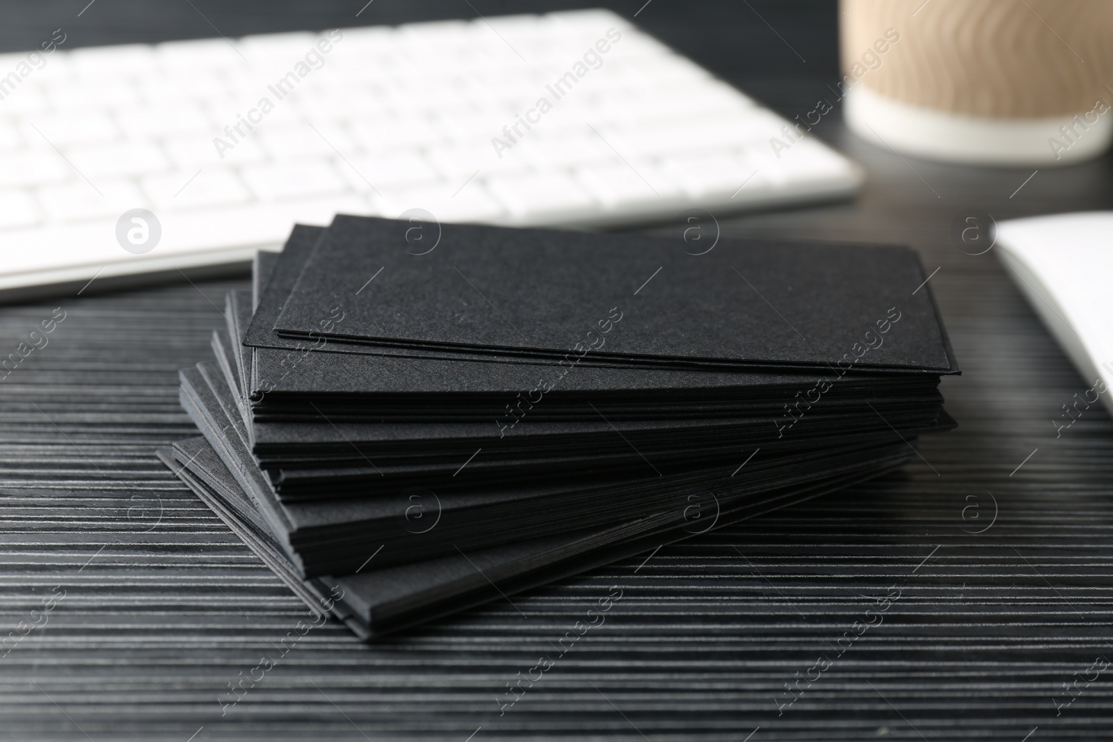 Photo of Blank black business cards on wooden table, closeup. Mockup for design