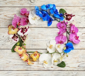 Photo of Beautiful tropical orchid flowers on white wooden background, top view. Space for text