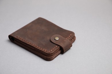 Photo of Stylish brown leather wallet on light grey background. Space for text