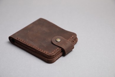 Stylish brown leather wallet on light grey background. Space for text