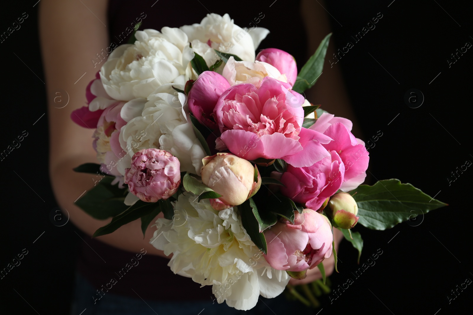 Photo of Woman with bouquet of beautiful peonies on black background, closeup