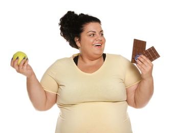 Photo of Happy overweight woman with apple and chocolate on white background