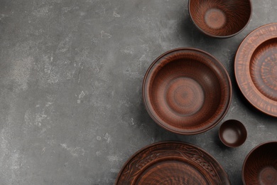 Photo of Set of clay utensils on grey table, flat lay. Space for text