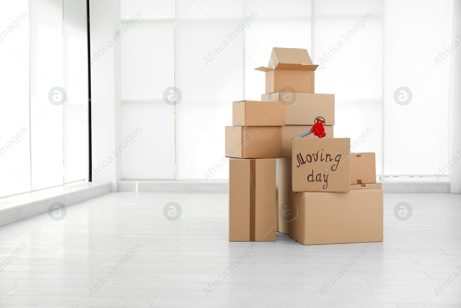 Photo of Pile of moving boxes in empty room