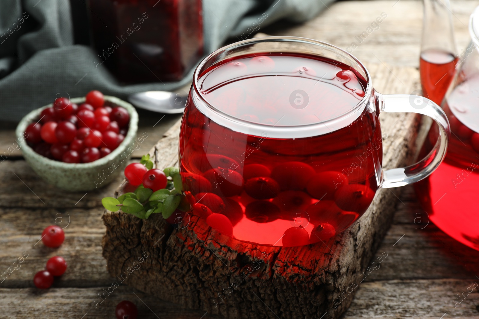 Photo of Delicious cranberry tea and berries on wooden table, closeup