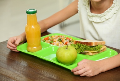 Photo of Child with healthy food for school lunch at desk, closeup