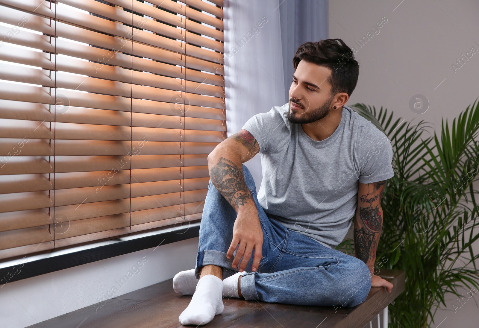 Photo of Young man relaxing near window at home