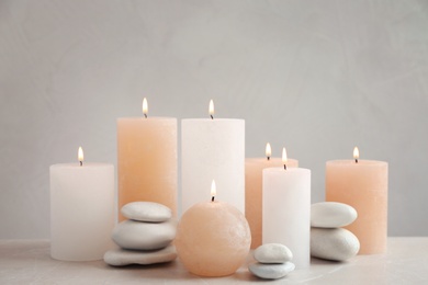 Beautiful composition with candles on table against grey background