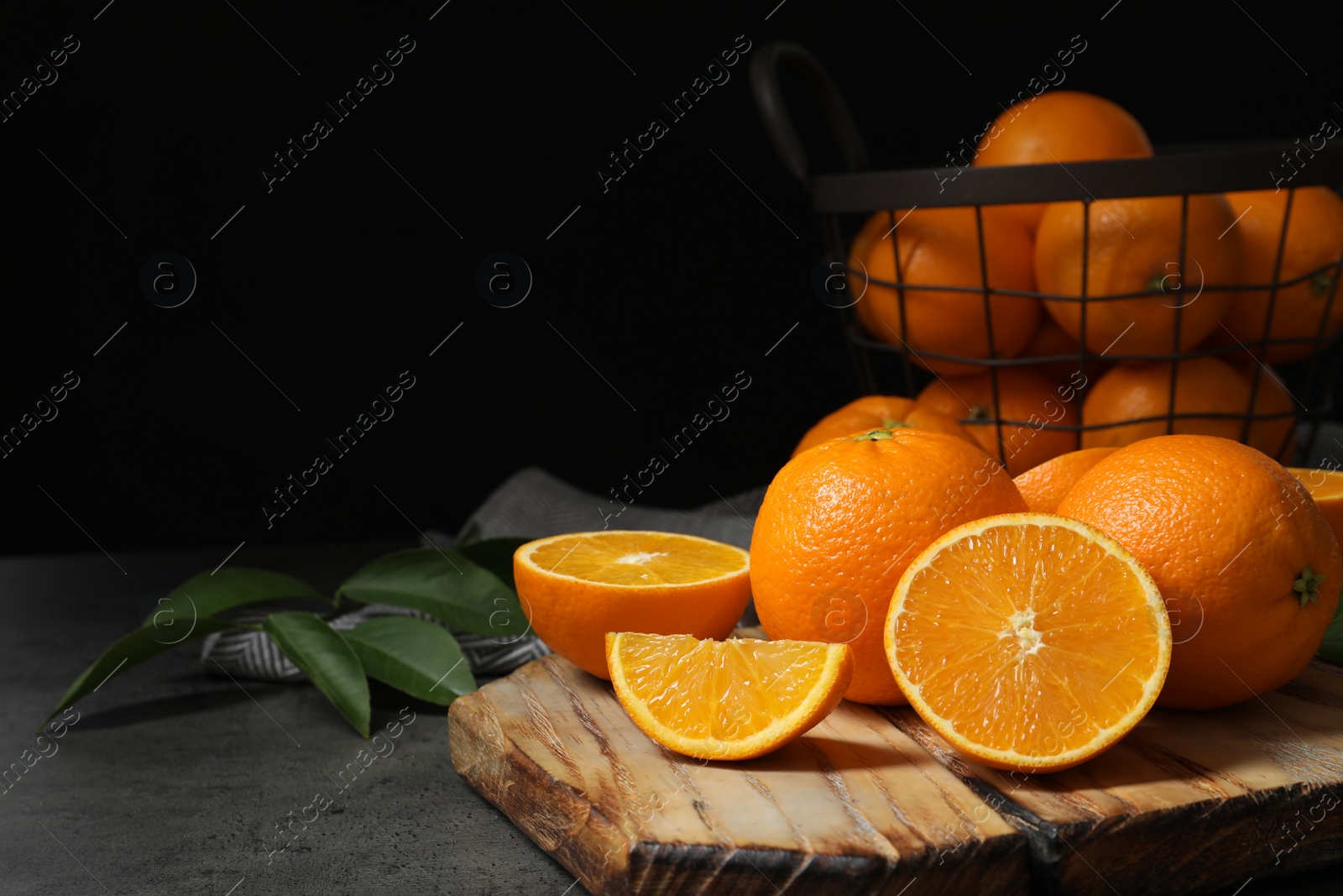 Photo of Wooden board with ripe oranges on table. Space for text