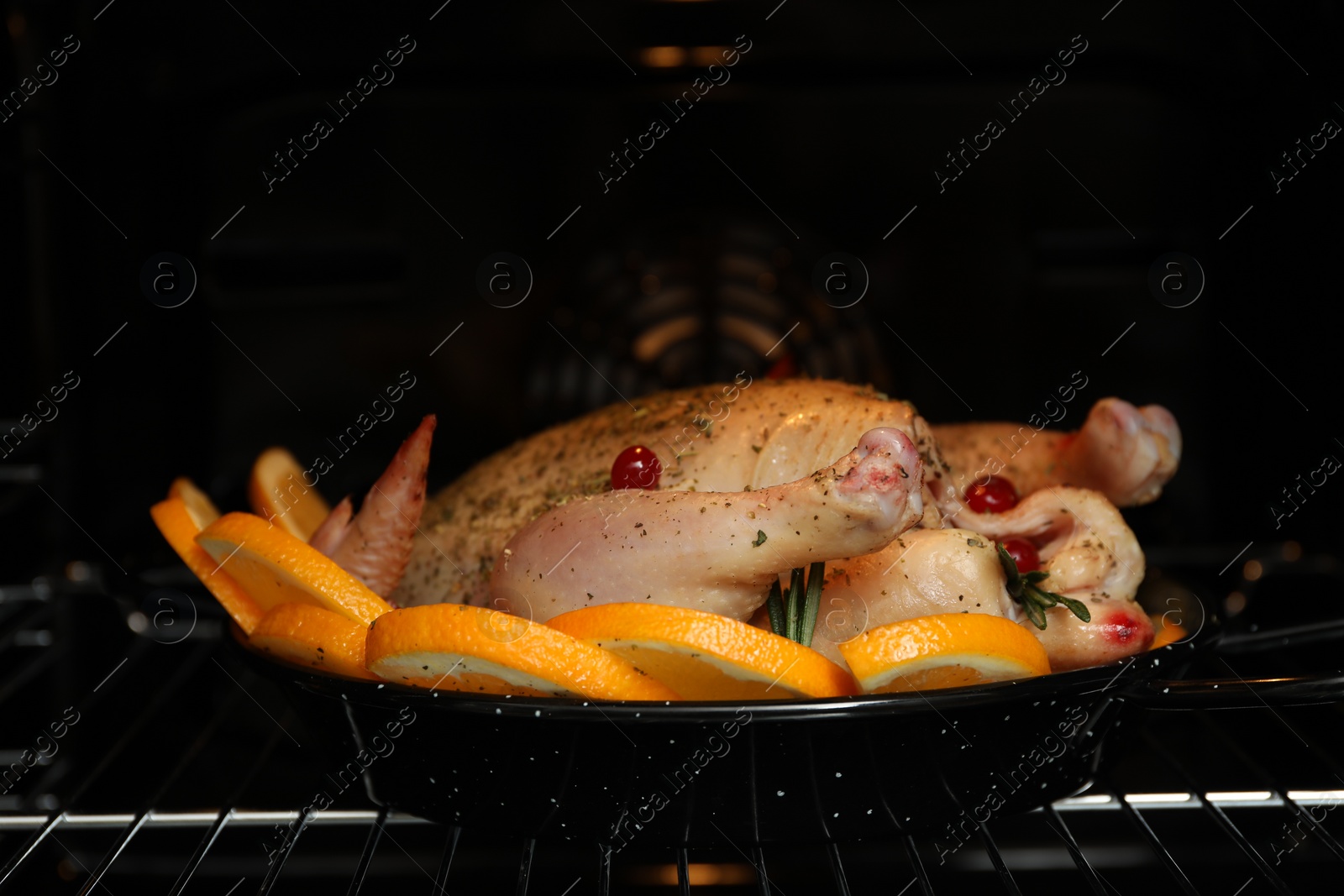 Photo of Chicken with orange slices baking in oven