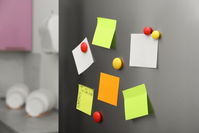 Paper sheets and magnets on refrigerator door indoors