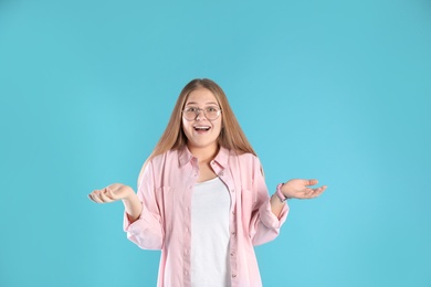 Portrait of emotional teenage girl on color background