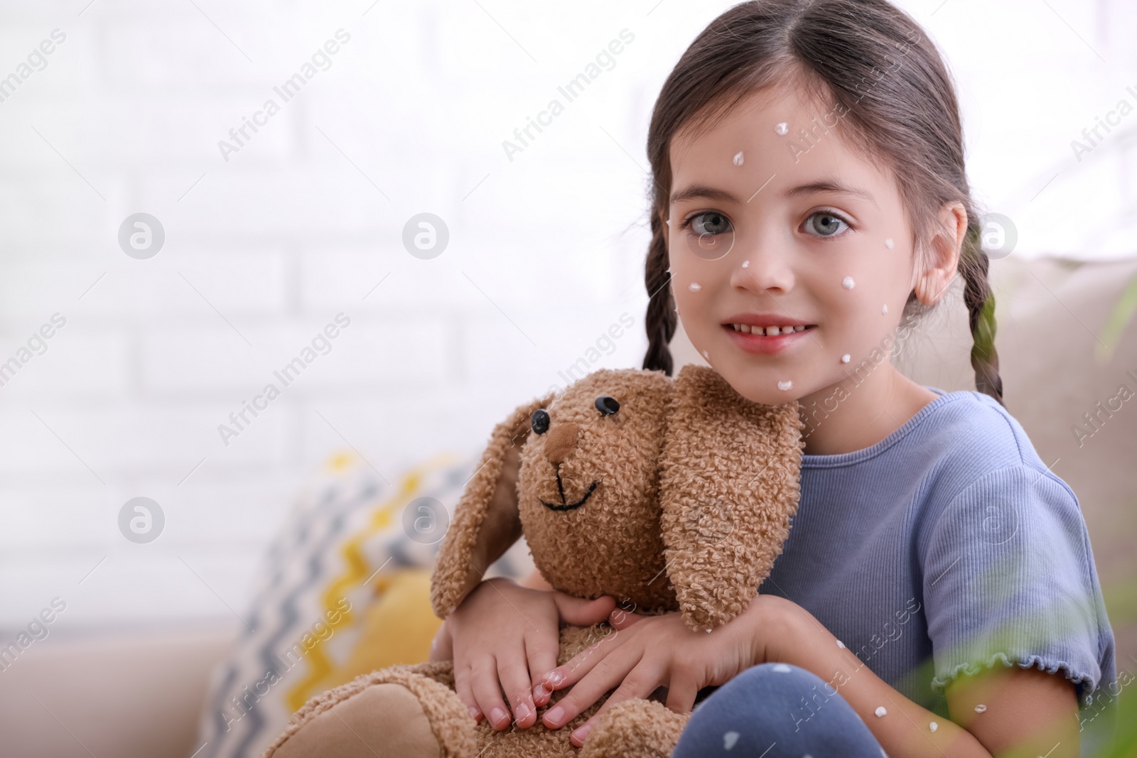 Photo of Little girl with chickenpox playing at home. Space for text