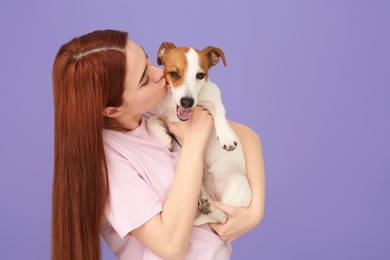 Photo of Woman kissing cute Jack Russell Terrier dog on violet background. Space for text