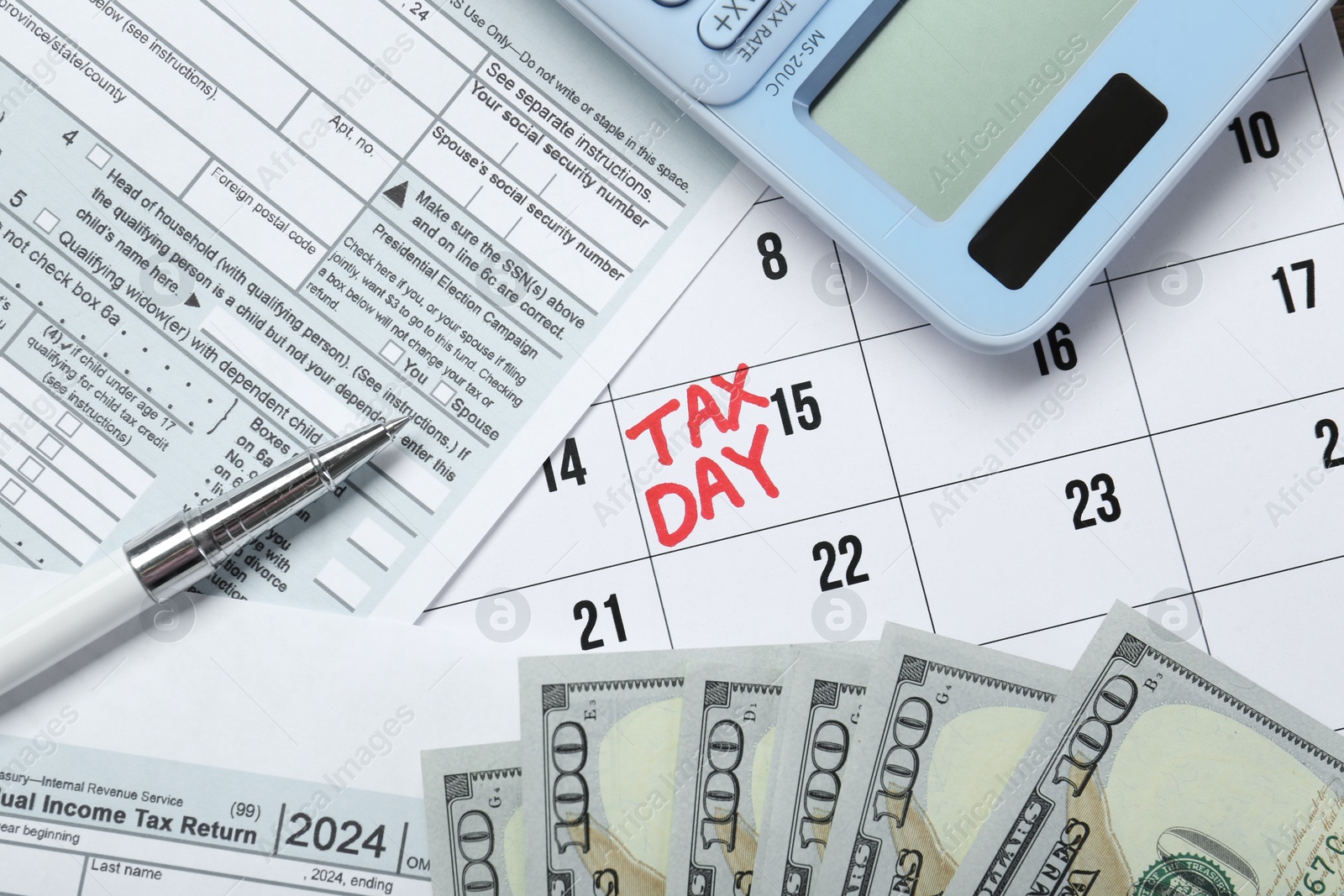 Photo of Calendar with date reminder about tax day, documents, money, pen and calculator, top view