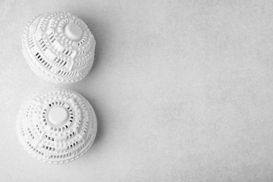 Photo of Laundry dryer balls on light grey table, flat lay. Space for text