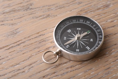 One compass on wooden table, space for text. Tourist equipment