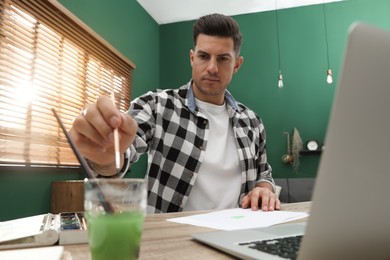 Man drawing with paints at online lesson indoors. Distance learning