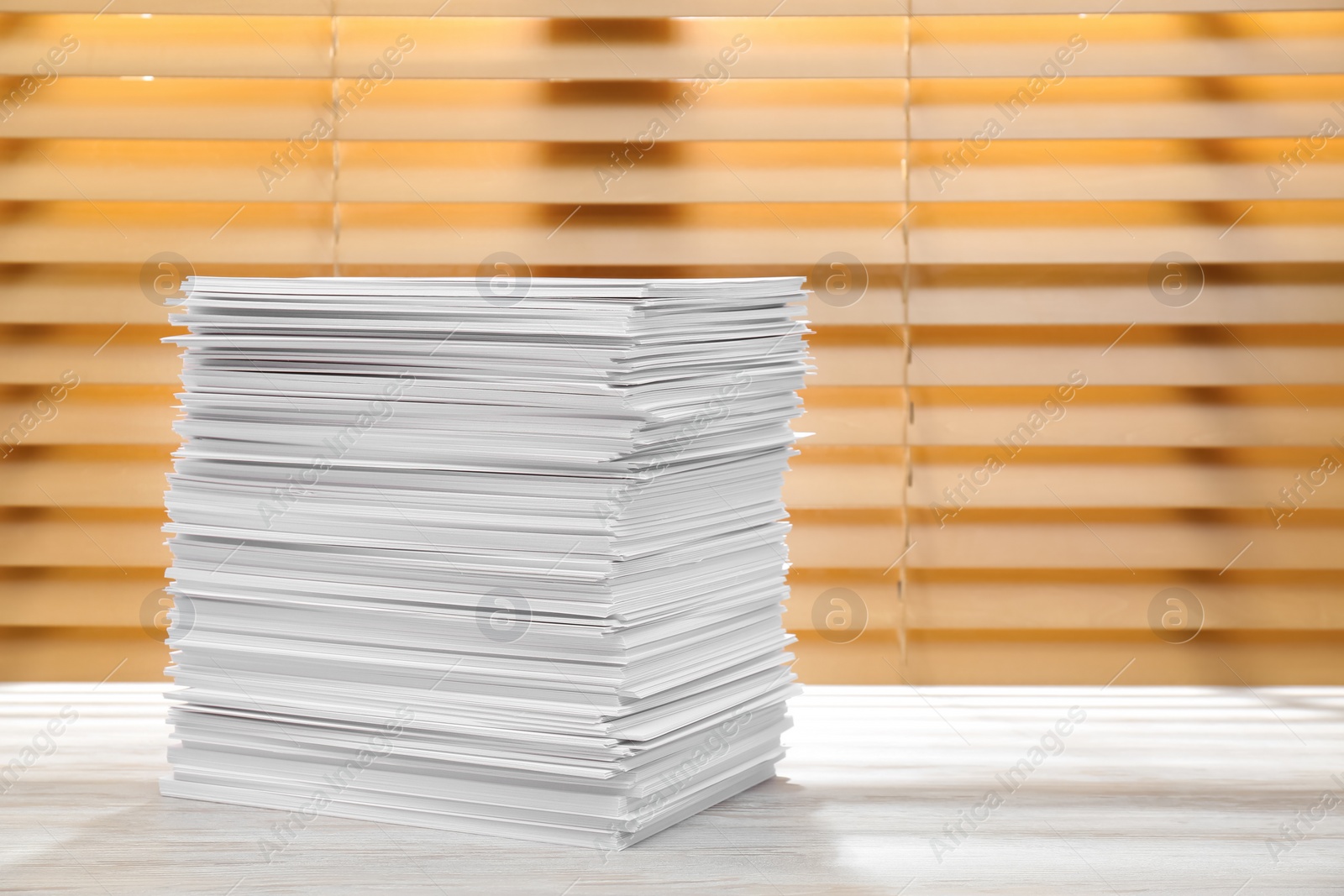 Photo of Stack of paper sheets on white wooden table. Space for text